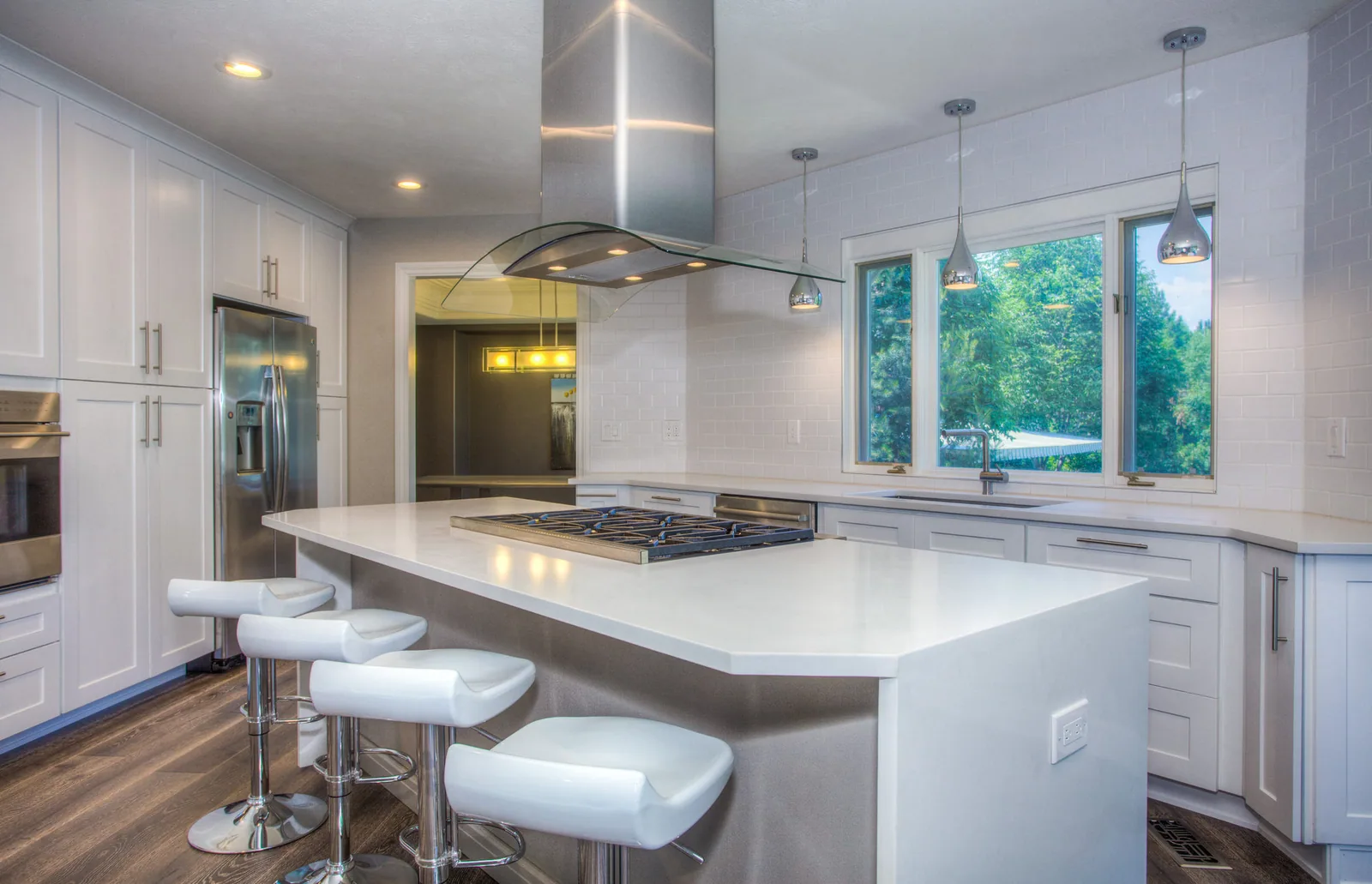 After: an open architectural kitchen with waterfall stone island and integrated appliances
